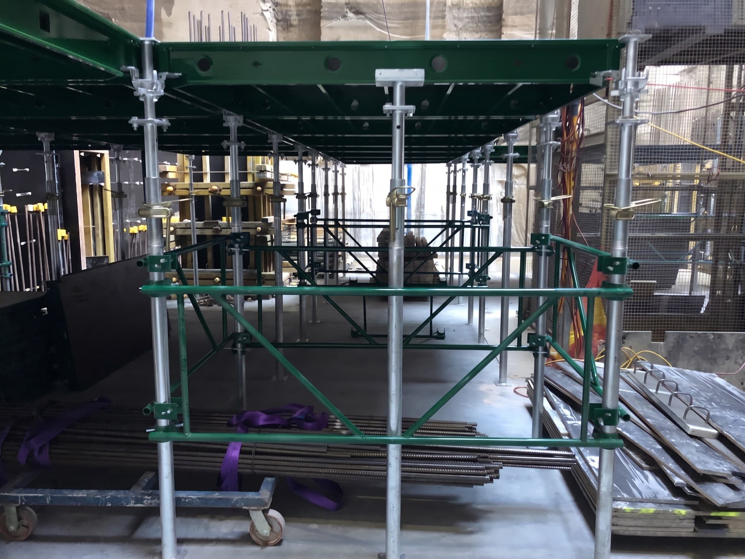 An Early Strip bay: deck panels bearing on fork heads, with guardrail frames and diagonal braces spanning between the props