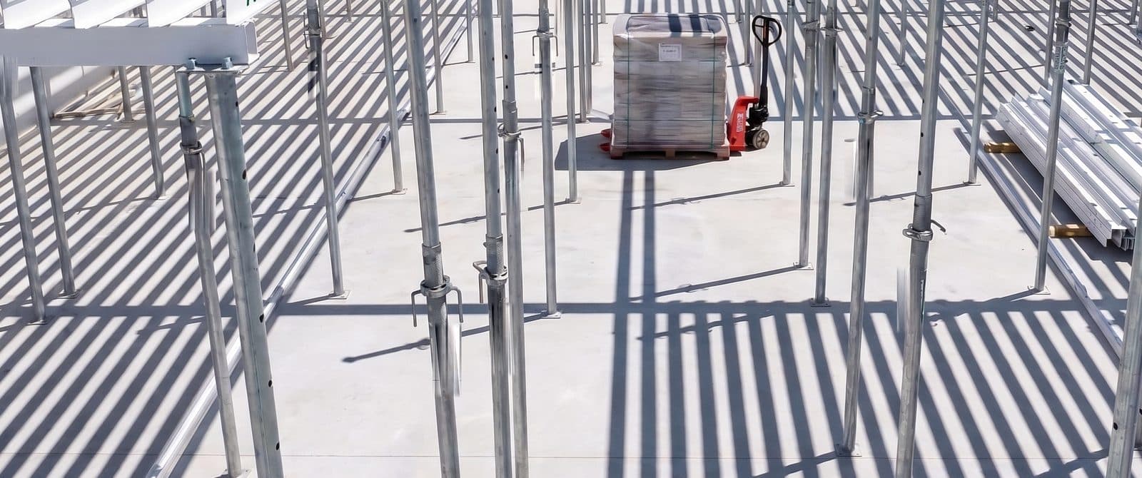 A matrix bay in service, props and beams casting a grid of shadow across the slab