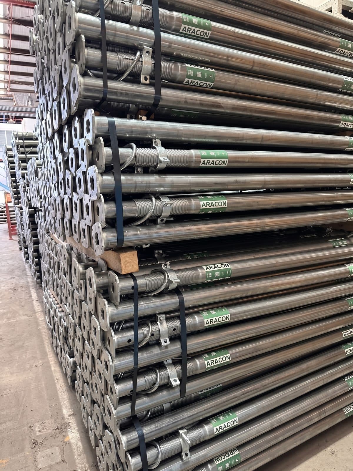 Steel props racked in stock, each bundle carrying a green ARACON label